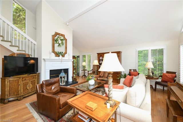 8009 Willow Glen Trl, Greensboro, NC 27455 - living room featuring lofted ceiling, light wood-style flooring, stairway, and a fireplace