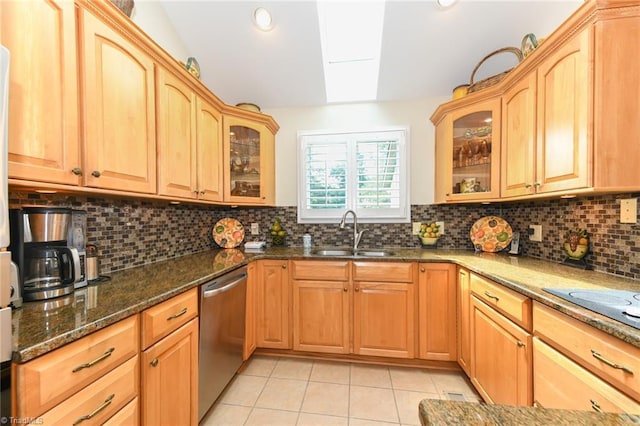8009 Willow Glen Trl, Greensboro, NC 27455 - kitchen with a sink, dishwasher, light tile patterned floors, a skylight, and dark stone countertops