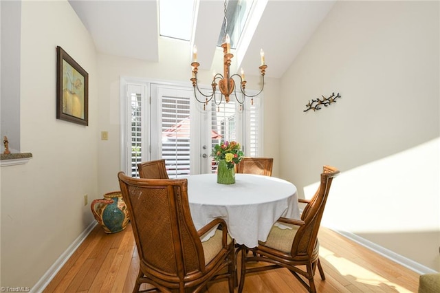 8009 Willow Glen Trl, Greensboro, NC 27455 - dining room with a chandelier, light wood finished floors, baseboards, and lofted ceiling