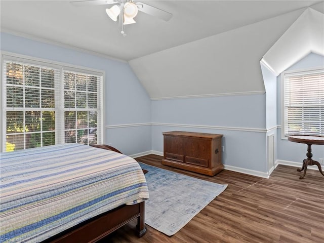 bedroom with vaulted ceiling, ceiling fan, dark hardwood / wood-style floors, and multiple windows