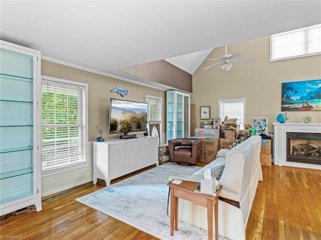 living room with ceiling fan, light wood-type flooring, and vaulted ceiling