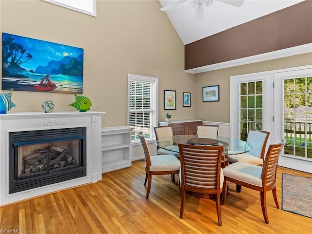 dining space featuring ceiling fan, light hardwood / wood-style floors, and high vaulted ceiling