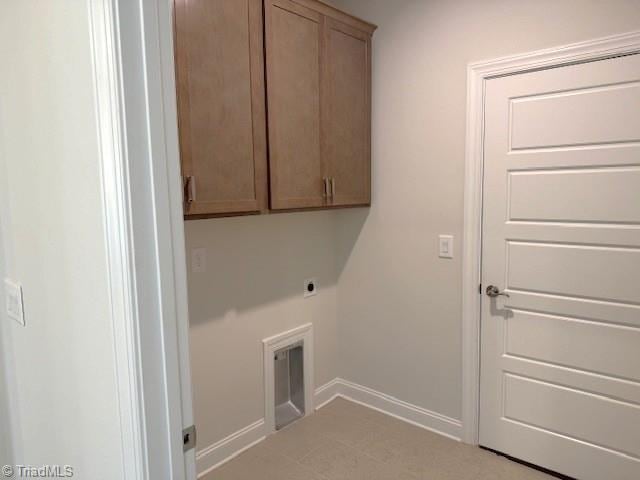 washroom featuring electric dryer hookup, baseboards, and cabinet space
