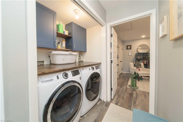 laundry area with cabinet space, washing machine and clothes dryer, attic access, and light wood-type flooring
