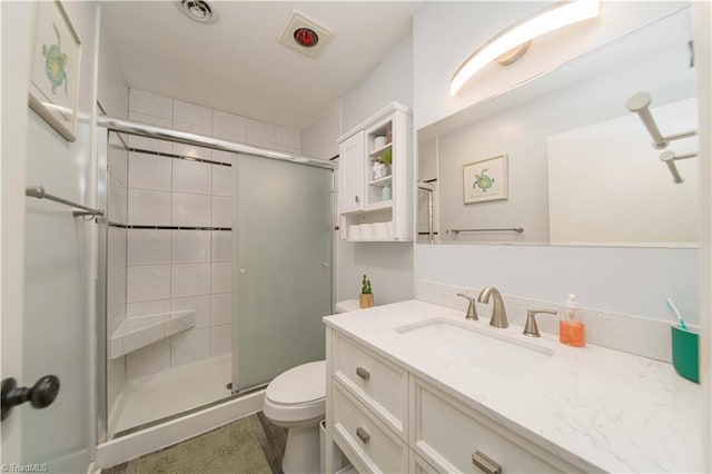 bathroom featuring toilet, a stall shower, and vanity