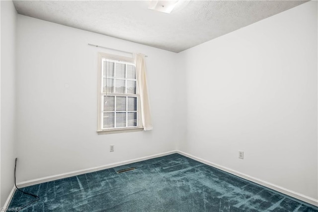 carpeted spare room with a textured ceiling