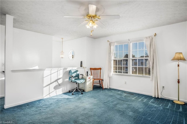 living area featuring carpet flooring, ceiling fan, and a textured ceiling