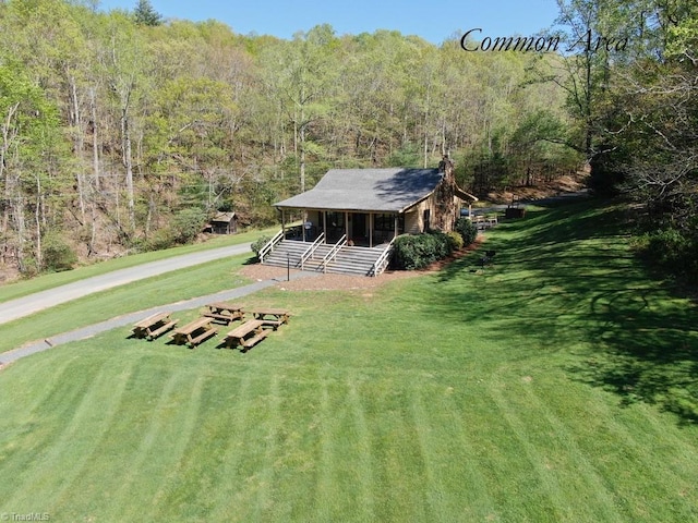 exterior space featuring covered porch and a front yard