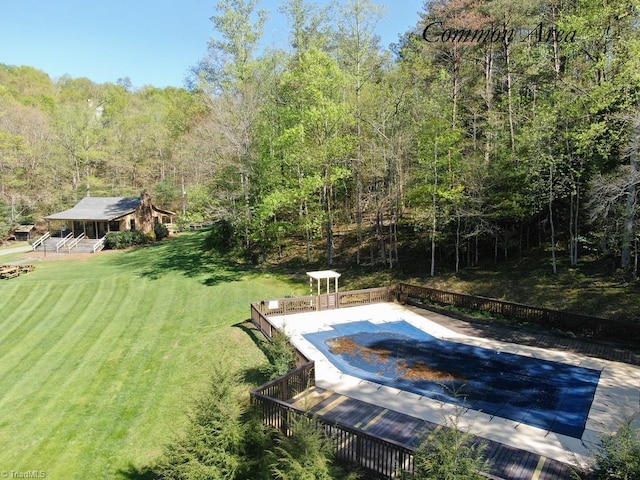 view of swimming pool featuring a yard