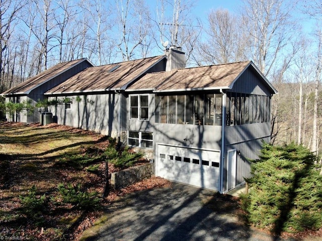 view of side of home featuring a garage and a sunroom