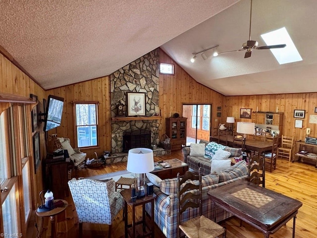 living room with plenty of natural light, wooden walls, and light hardwood / wood-style flooring