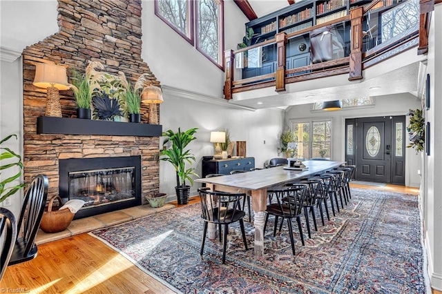 dining room with a stone fireplace and hardwood / wood-style floors