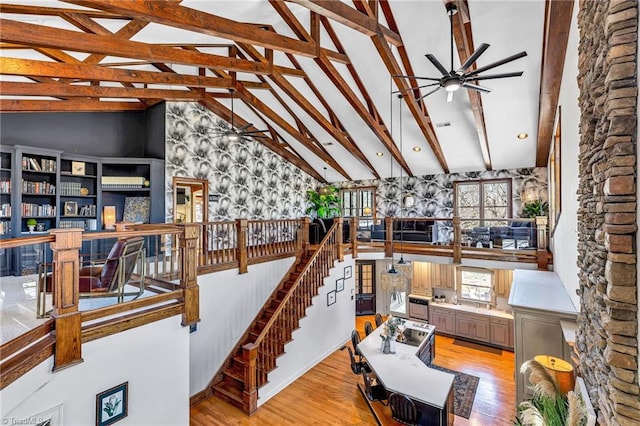 stairway featuring beam ceiling, wood-type flooring, high vaulted ceiling, and ceiling fan