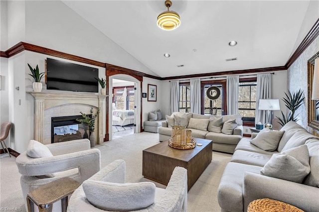 carpeted living room with high vaulted ceiling, a fireplace, and ornamental molding