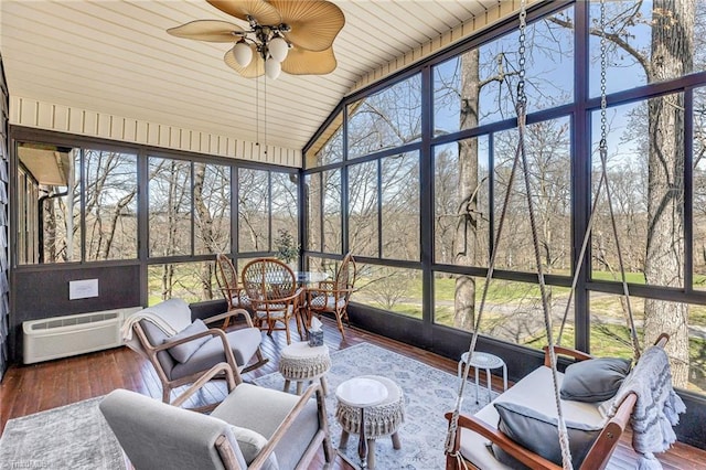 sunroom featuring lofted ceiling, a wall mounted air conditioner, and ceiling fan
