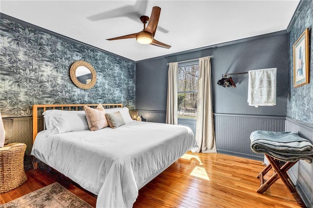 bedroom with hardwood / wood-style flooring, ornamental molding, and ceiling fan