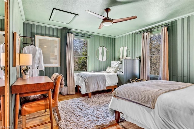 bedroom with multiple windows, ceiling fan, a textured ceiling, and light wood-type flooring