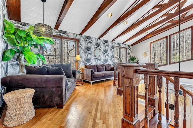 living room with vaulted ceiling with beams and light wood-type flooring