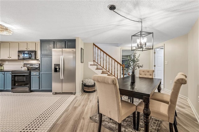 dining area with a notable chandelier, a textured ceiling, and light hardwood / wood-style flooring