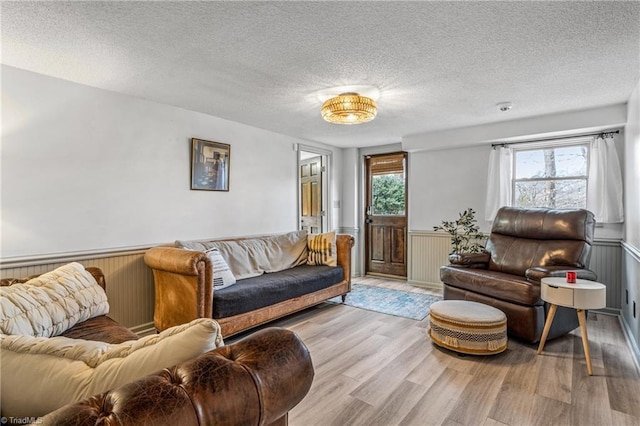 living room featuring a textured ceiling and light wood-type flooring