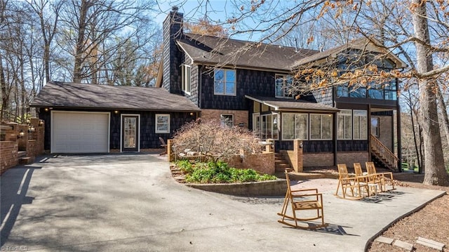 view of property featuring a garage and a sunroom