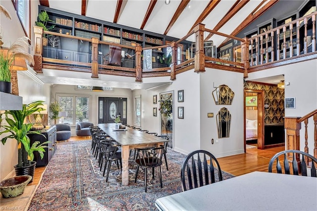 dining space with hardwood / wood-style flooring, high vaulted ceiling, and beam ceiling