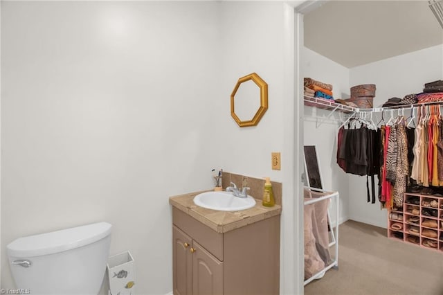 206 Westwood Dr, Kernersville, NC 27284 - bathroom featuring toilet, baseboards, vanity, and a walk in closet