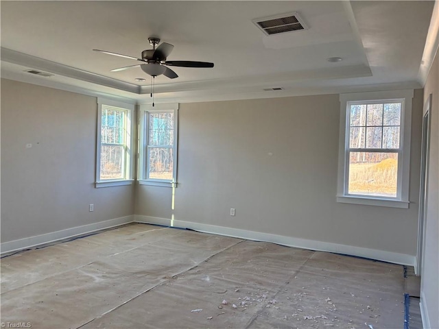 unfurnished room with a raised ceiling, visible vents, and a wealth of natural light