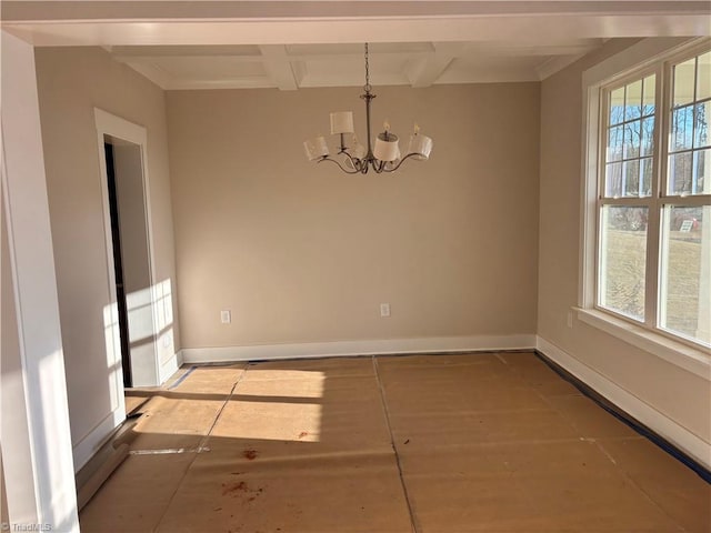 empty room featuring baseboards, plenty of natural light, coffered ceiling, and a chandelier