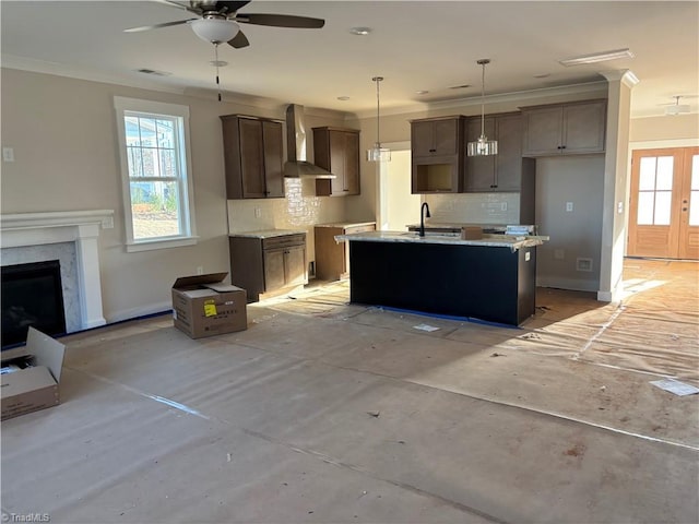 kitchen featuring visible vents, a ceiling fan, wall chimney range hood, and decorative backsplash