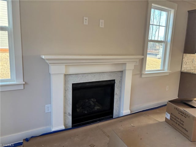 interior details with baseboards and a fireplace