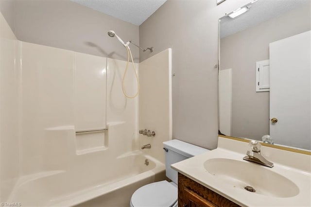 bathroom with a textured ceiling, vanity, toilet, and  shower combination