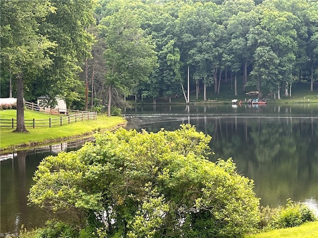 view of home's community featuring a water view, fence, and a lawn