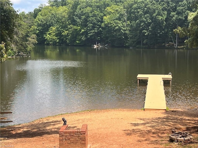 dock area with a water view and a wooded view