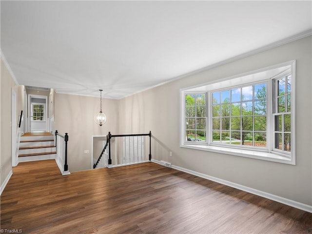 unfurnished room featuring baseboards, a notable chandelier, visible vents, and wood finished floors