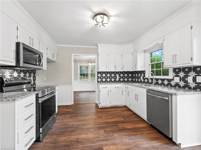 kitchen featuring plenty of natural light, ornamental molding, stainless steel appliances, and dark wood-style flooring