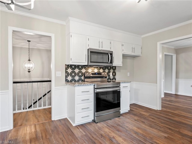 kitchen featuring white cabinets, a wainscoted wall, stainless steel appliances, and dark wood-type flooring