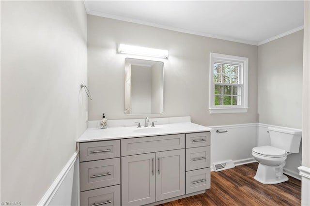 bathroom featuring toilet, wood finished floors, visible vents, and crown molding