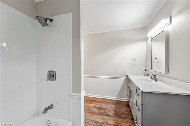 bathroom with  shower combination, baseboards, wood finished floors, and vanity