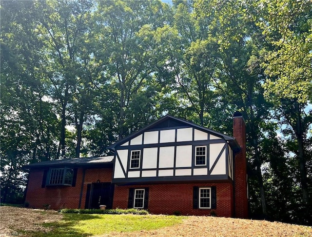 tudor house with a chimney and brick siding