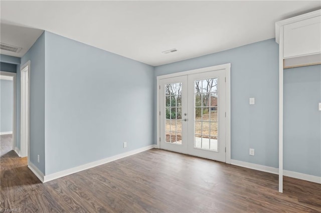 spare room with dark wood-type flooring and french doors