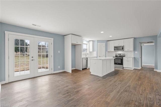 kitchen featuring a center island, french doors, white cabinetry, wood-type flooring, and stainless steel appliances