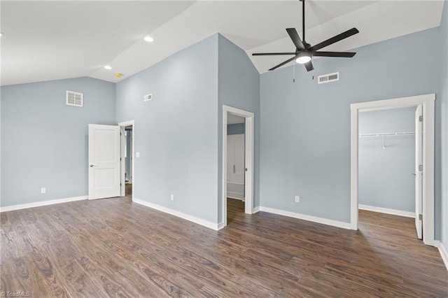 interior space featuring ceiling fan, a walk in closet, dark wood-type flooring, and high vaulted ceiling