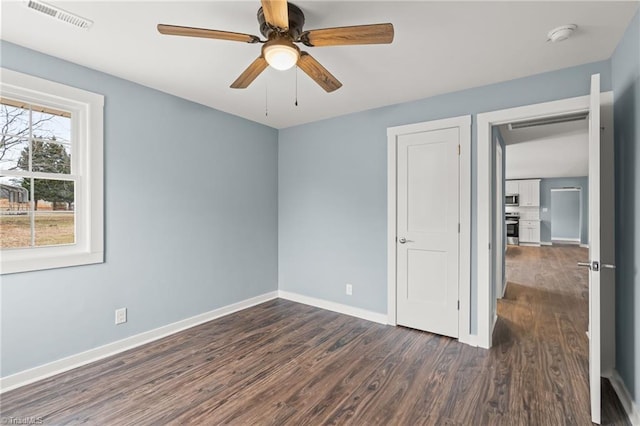 unfurnished room with ceiling fan and dark wood-type flooring