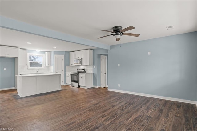 unfurnished living room featuring ceiling fan, dark wood-type flooring, and sink