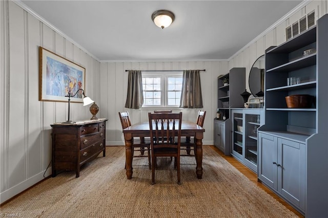 dining space featuring crown molding and light hardwood / wood-style floors