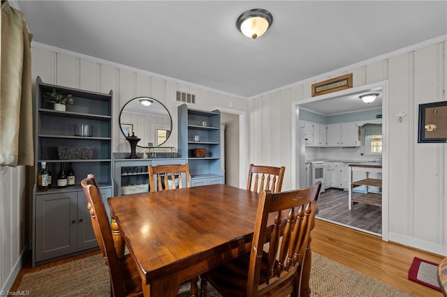 dining area featuring crown molding and wood-type flooring