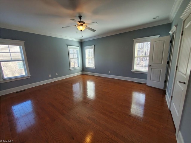 spare room featuring ornamental molding, dark wood-style flooring, and baseboards