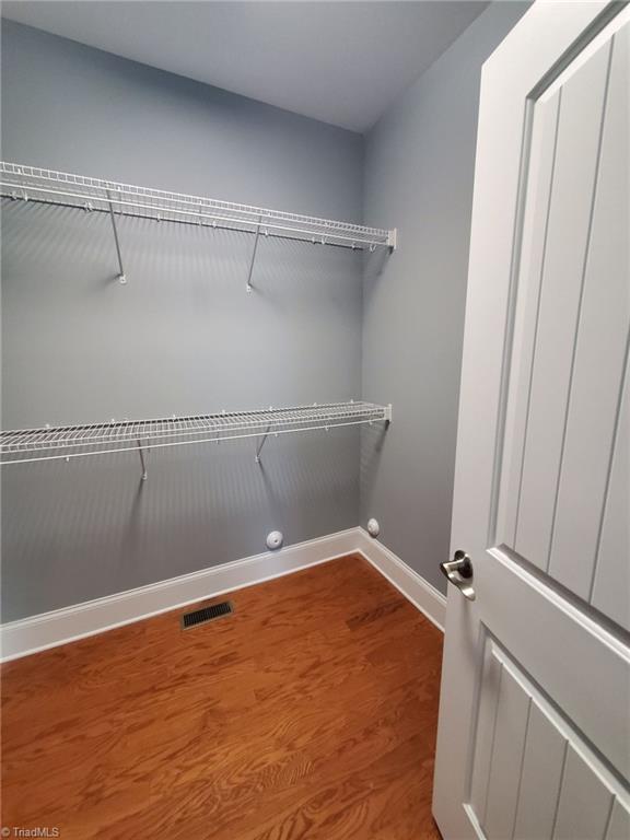 spacious closet with visible vents and wood finished floors