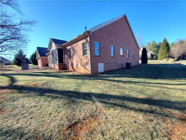 view of property exterior with crawl space, a yard, central AC, and brick siding